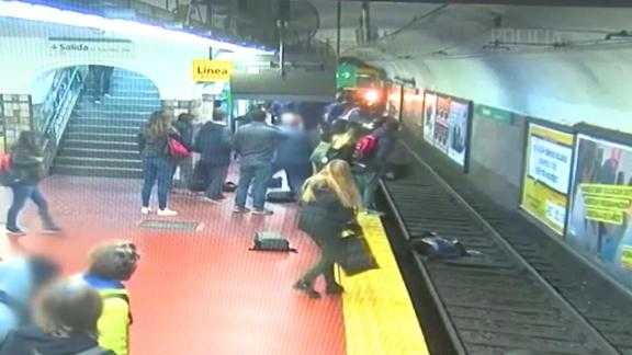 Moment woman falls onto subway tracks and is pulled to safety