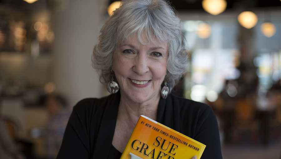 Detective novelist Sue Grafton poses with her 23rd book 'W' at a coffee shop in the Toronto Reference Library, October 3, 2013. 