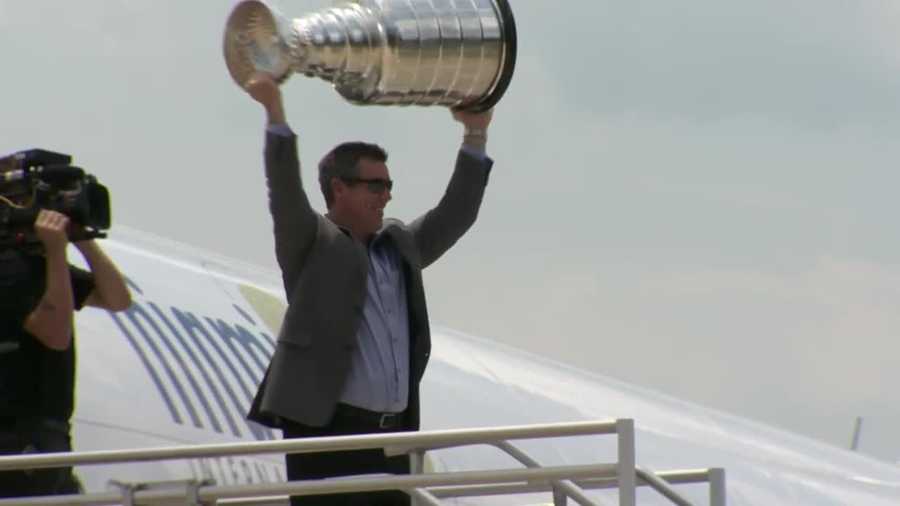 Penguins coach Mike Sullivan holds the Stanley Cup over his head.