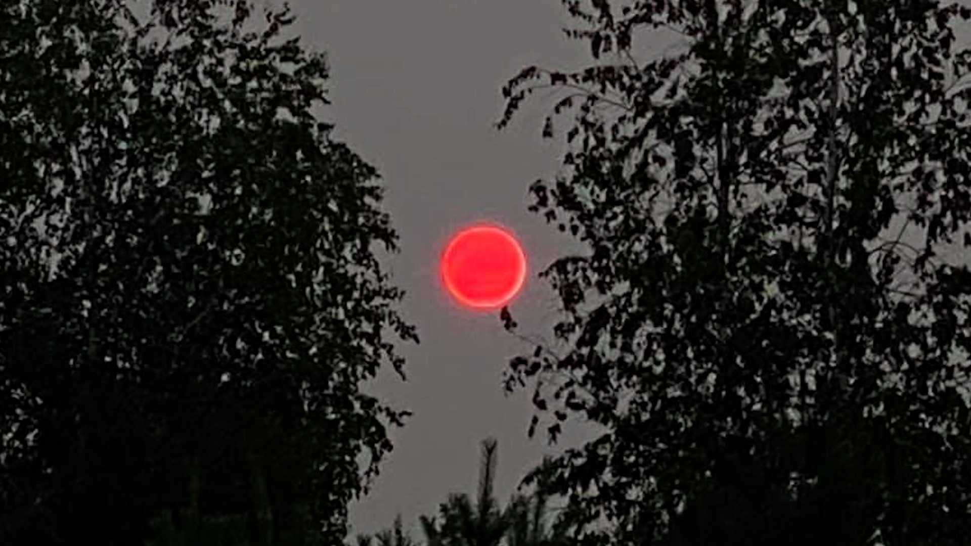Sun appears bright orangered due to hazy conditions caused by smoke from the western wildfires