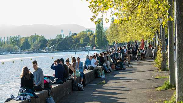 LAUSANNE, SWITZERLAND - MAY 03: People sit outside by the lake Leman during the coronavirus pandemic on May 3, 2021 in Lausanne, Switzerland.