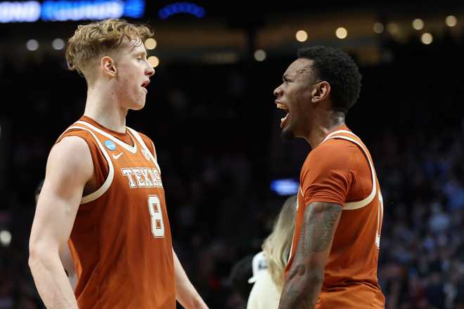 Texas center Matas Vokietaitis (8) celebrates with forward Nic Codie after the second round of the NCAA college basketball tournament against Gonzaga, Saturday, March 21, 2026, in Portland, Ore.
