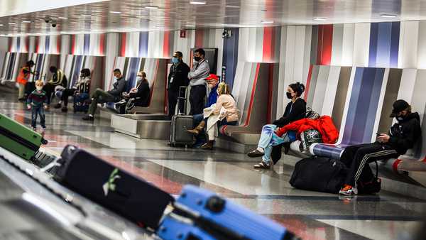 People wait for their baggage at Boston Logan International Airport in Boston on Nov. 25, 2020.