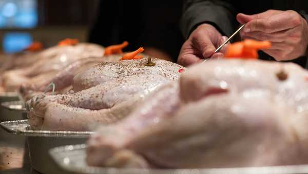 WASHINGTON, DC - OCTOBER 28: Tim Carman, food writer for The Washington Post via Getty Images, inserts a thermometer into one of several uncooked turkeys during a pop-up timer evaluation at the CulinAerie cooking school in Washington, D.C. on Oct. 28, 2015. (Photo by Joshua Yospyn/For The Washington Post via Getty Images)