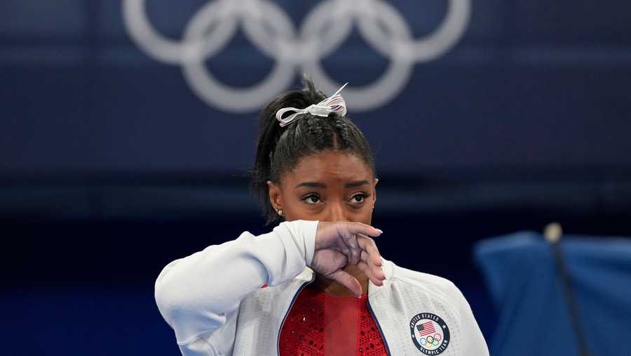 Simone Biles, of the United States, watches gymnasts perform at the 2020 Summer Olympics, Tuesday, July 27, 2021, in Tokyo. Biles says she wasn't in right 'headspace' to compete and withdrew from gymnastics team final to protect herself.