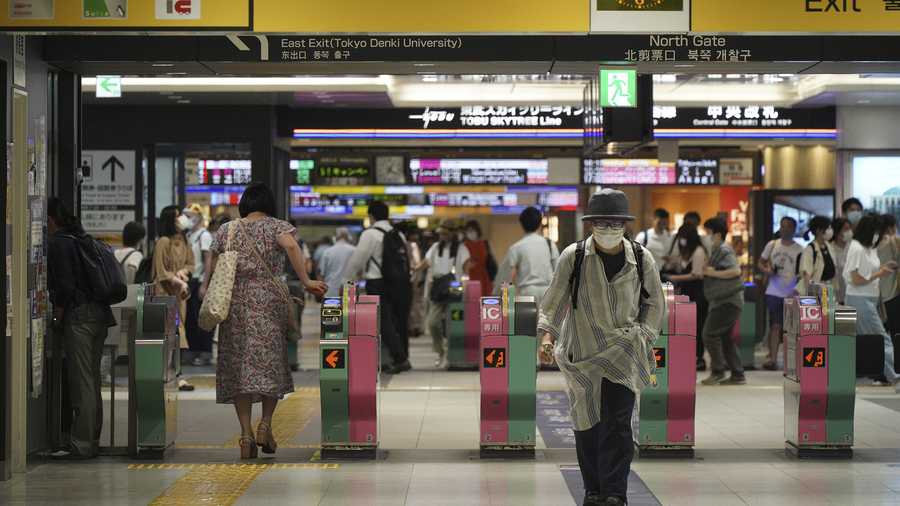 Passengers pass through the gates of a subway station in Tokyo, Friday, Aug. 6, 2021. A man stabbed four passengers with a knife on a Tokyo subway on Friday and was arrested by police after fleeing, a railway official and news reports said.