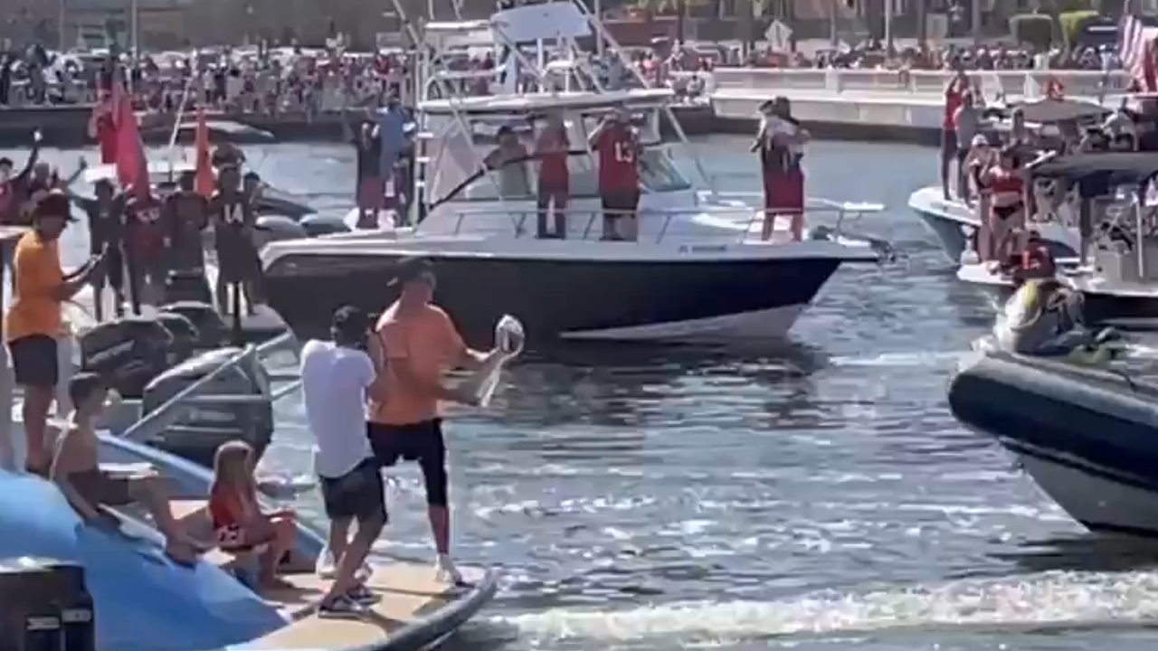 brady throws lombardi trophy to boat