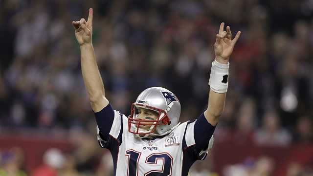New England Patriots' Tom Brady raises his arms after scoring a touchdown during overtime of the NFL Super Bowl 51 football game against the Atlanta Falcons, Sunday, Feb. 5, 2017, in Houston.