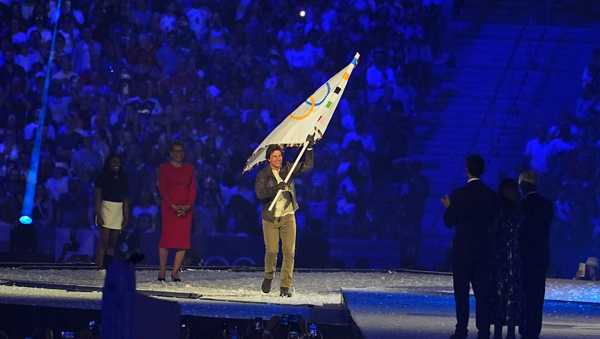 Hollywood star Tom Cruise (C) takes part in a section which sees the Olympic Flag transferred from Paris to the 2028 host city, Los Angeles, during the closing ceremony of the Paris 2024 Olympic Games at the Stade de France on August 11, 2024 in Saint-Denis, Paris, France.