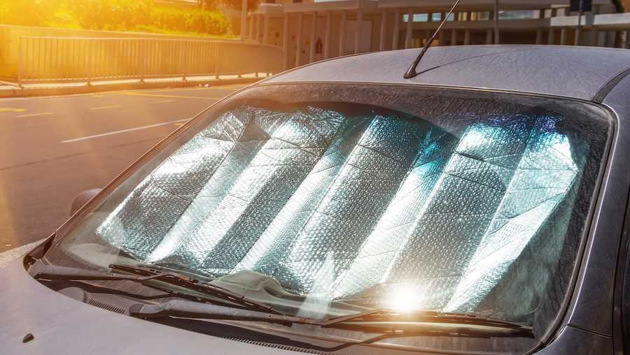 Protective reflective surface under the windshield of the passenger car parked on a hot day, heated by the sun's rays inside the car