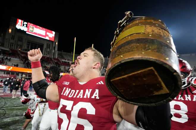 FILE - Indiana&apos;s Mike Katic celebrates with the Old Oaken Bucket after defeating Purdue in an NCAA college football game, Saturday, Nov. 30, 2024, in Bloomington, Ind.
