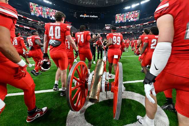 FILE - UNLV pulls the Fremont Cannon trophy, awarded to the winner of the annual Battle of Nevada game, on the field after defeating Nevada in an NCAA college football game Saturday, Nov. 30, 2024, in Las Vegas.