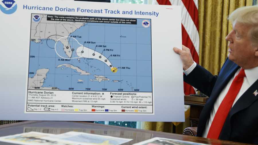 President Donald Trump holds a chart as he talks with reporters after receiving a briefing on Hurricane Dorian in the Oval Office of the White House, Wednesday, Sept. 4, 2019, in Washington.