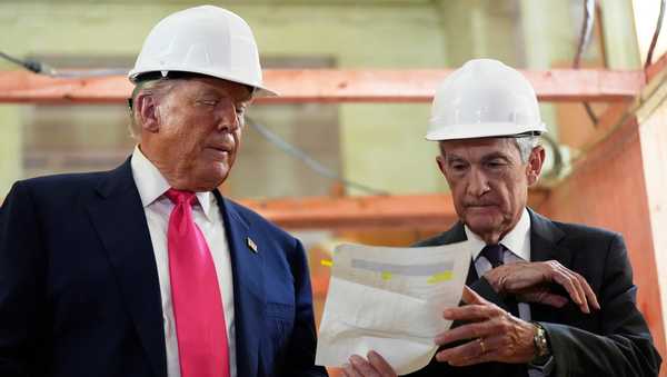 FILE - Federal Reserve Chairman Jerome Powell, right, and President Donald Trump look over a document of cost figures during a visit to the Federal Reserve, Thursday, July 24, 2025, in Washington.