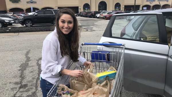 Cassandra Schoborg, a third-year UC medical student, packs groceries as part of an effort to assist seniors and others at risk of COVID-19.