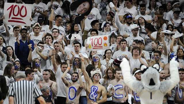 UConn students hold up 100 signs and cheer for the team in the second half of an NCAA college basketball game against South Carolina, Monday, Feb. 13, 2017, in Storrs, Conn.