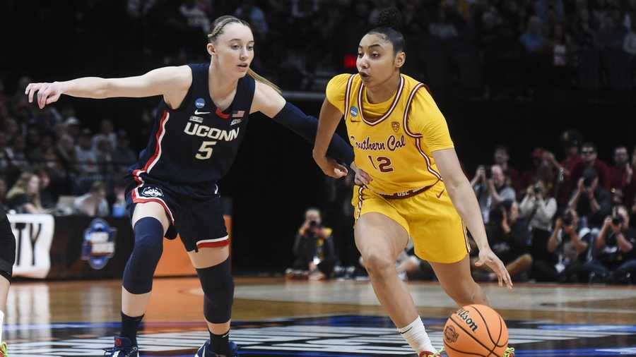 Southern California guard JuJu Watkins (12) drives to the basket past UConn guard Paige Bueckers (5) during the first half of an Elite Eight college basketball game in the women&apos;s NCAA Tournament, Monday, April 1, 2024, in Portland, Ore.
