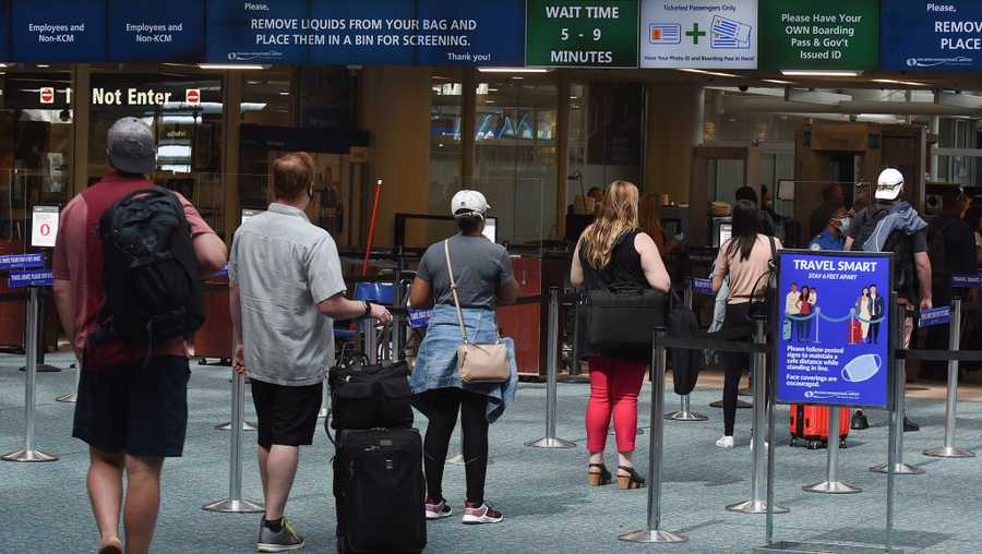 A sign reminds passengers to stay 6 feet apart is seen at a screening checkpoint at Orlando International Airport.