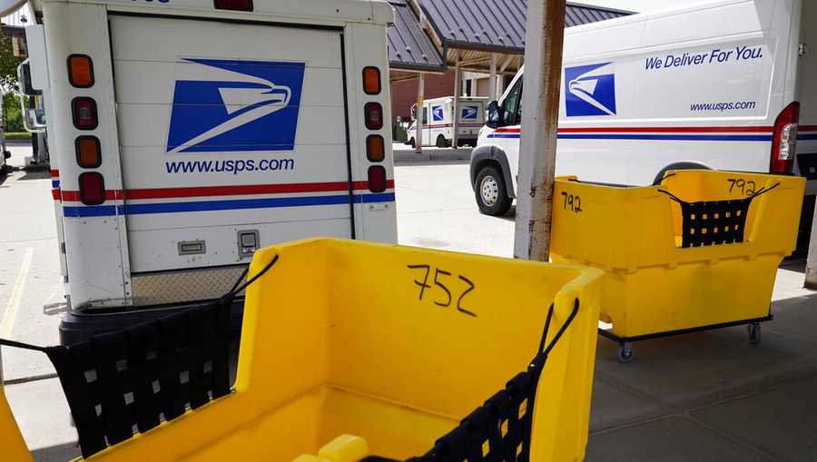 Mail delivery vehicles are parked outside a post office in Boys Town, Neb., Tuesday, Aug. 18, 2020. The Postmaster general announced Tuesday he is halting some operational changes to mail delivery that critics warned were causing widespread delays and could disrupt voting in the November election. Postmaster General Louis DeJoy said he would "suspend" his initiatives until after the election "to avoid even the appearance of impact on election mail."