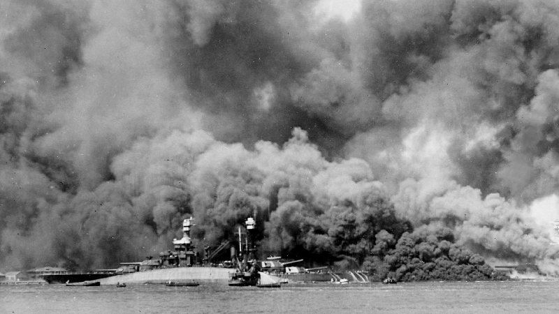 USS Oklahoma (left of center, closest to camera) capsizes on Dec. 7, 1941