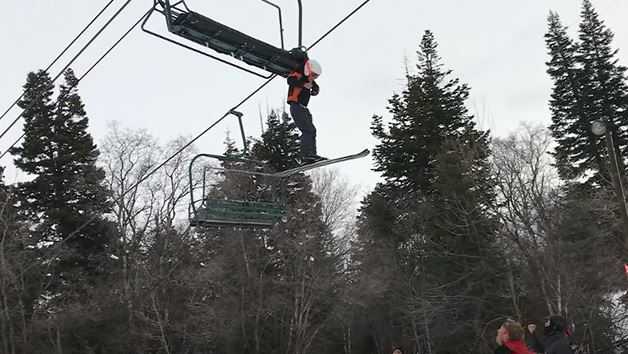 A young boy dangles from a Utah ski lift.