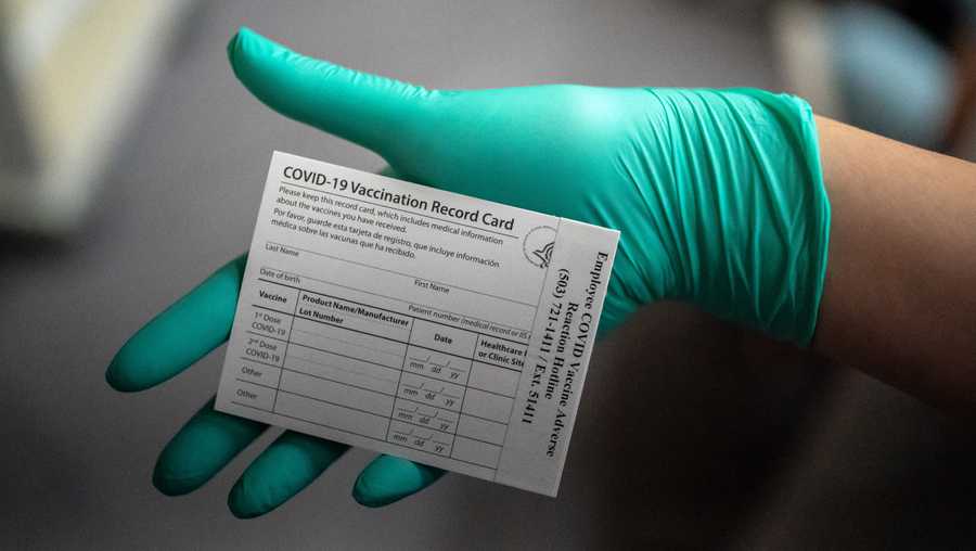 A healthcare worker displays a COVID-19 vaccine record card at the Portland Veterans Affairs Medical Center on December 16, 2020 in Portland, Oregon.