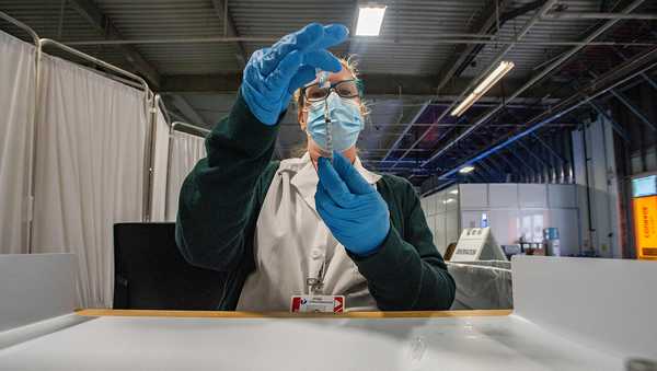 Pharmacist Kathie McDonough reconstitutes the Pfizer-BioNTech COVID-19 vaccine as she fills syringes with the vaccine for the incoming public at the UMass Memorial Health Care COVID-19 Vaccination Center in the Mercantile Center in Worcester, Massachusetts on April 22, 2021.