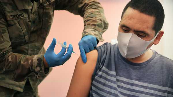 Maryland National Guard Specialist James Truong (L) administers a Moderna coronavirus vaccine at CASA de Maryland's Wheaton Welcome Center on May 21 in Wheaton, Maryland.