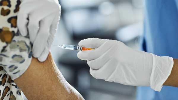 Nurse injecting Covid-19 Vaccine to a patient.
