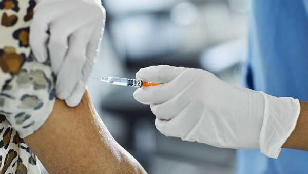Nurse injecting Covid-19 Vaccine to a patient.