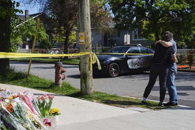 A couple hugs near the scene the day after a driver killed multiple people during a Filipino community festival Sunday, April 27, 2025, in Vancouver, British Columbia.