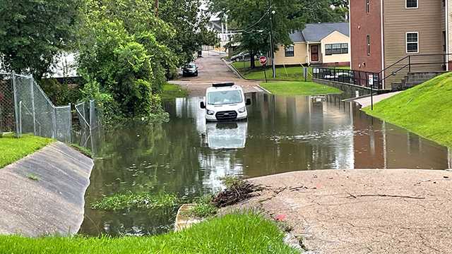 Man waits for help to arrive after driving onto flooded street