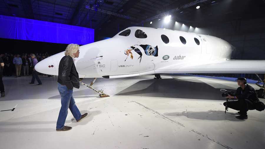 Sir Richard Branson walks in front of Virgin Galactic's space tourism rocket after it was unveiled in February 2016, in Mojave, Calif.