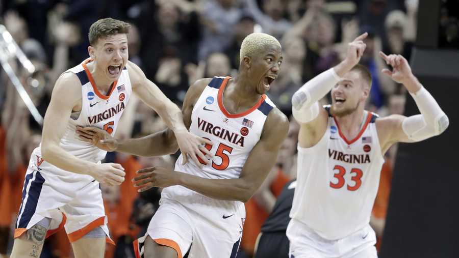 Virginia's Mamadi Diakite, center, reacts with teammates Kyle Guy and Jack Salt (33) after hitting a shot to send the game into overtime in the men's NCAA Tournament college basketball South Regional final game against Purdue, Saturday, March 30, 2019, in Louisville, Ky. 