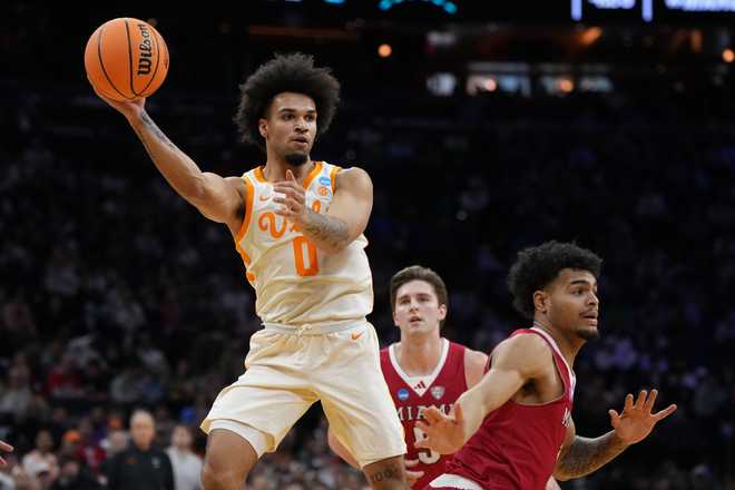 Tennessee's Ja'kobi Gillespie, left, passes behind Miami (Ohio)'s Trey Perry during the first half in the first round of the NCAA college basketball tournament, Friday, March 20, 2026, in Philadelphia.
