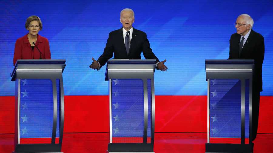 In this Feb. 7, 2020, file photo Democratic presidential candidate former Vice President Joe Biden, center, speaks as Sen. Elizabeth Warren, D-Mass., left, and Sen. Bernie Sanders, I-Vt., listen during a Democratic presidential primary debate hosted by ABC News, Apple News, and WMUR-TV at Saint Anselm College in Manchester, N.H.