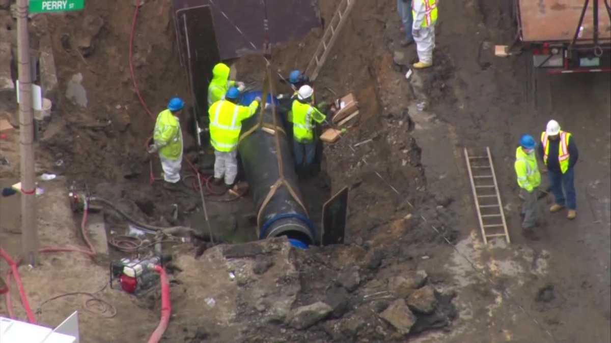 Repairs complete after water main break floods streets, traps car in ...
