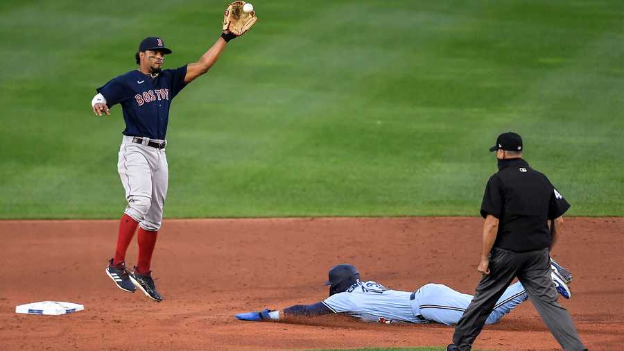 Boston Red Sox shortstop Xander Bogaerts, left, reaches for the throw as Toronto Blue Jays' Lourdes Gurriel Jr., center, slides into second with a stolen base during the second inning of a baseball game in Buffalo, N.Y., Wednesday, Aug. 26, 2020. (AP Photo/Adrian Kraus)