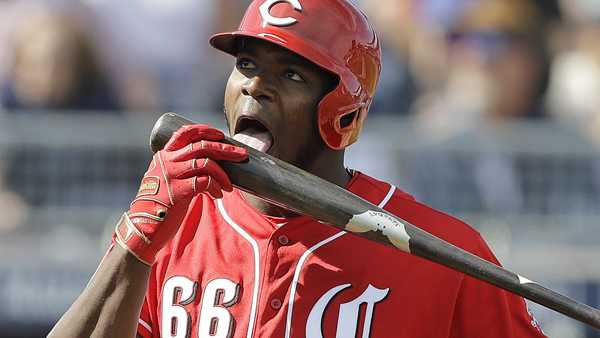 Cincinnati Reds' Yasiel Puig licks his bat during the third inning of a spring training baseball game against the Seattle Mariners, Monday, Feb. 25, 2019, in Peoria, Ariz. 