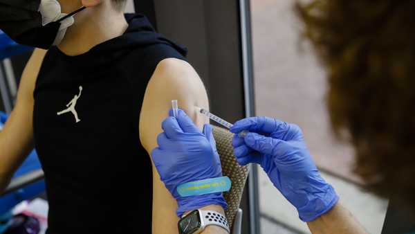 A health care worker administers a dose of the Pfizer-BioNTech Covid-19 vaccine to a teenager at Holtz Children's Hospital in Miami, Florida, U.S., on Wednesday, May 18, 2021.