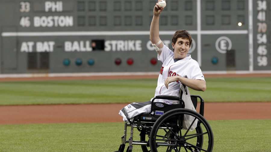 Boston Marathon bombing survivor Jeff Bauman acknowledges cheering fans before throwing out the ceremonial first pitch at Fenway Park prior to a baseball between the Boston Red Sox and the Philadelphia Phillies Tuesday, May 28, 2013, in Boston.