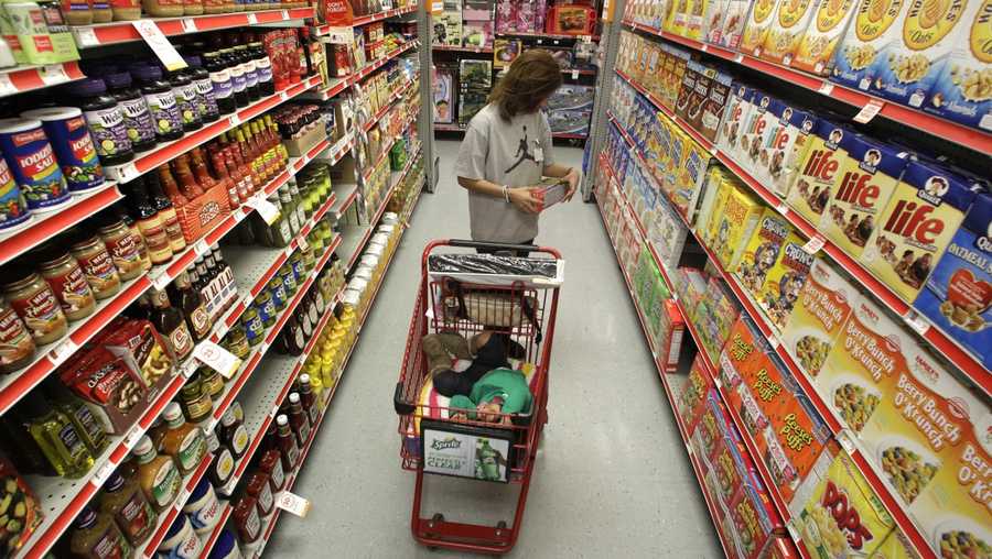 FILE - In this Dec. 14, 2010, file photo, Alicia Ortiz shops through the cereal aisle as her daughter Aaliyah Garcia catches a short nap in the shopping cart at a Family Dollar store in Waco, Texas. Up and down supermarket aisles, rows of perfectly placed products reflect calculated deliberations aimed at getting shoppers to spend more. Take cereal, for example. Research published in the Journal of Environment and Behavior found that kids’ cereals tended to be placed on lower shelves where they are more eye-level with children. It’s just one example of the tactics food companies and supermarkets use to sway what people put in their carts.