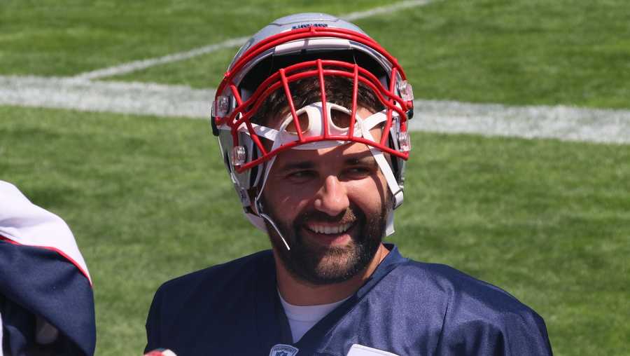 Patriots defensive end Rob Ninkovich smiles as he signs autographs for fans after the team's practice Monday.