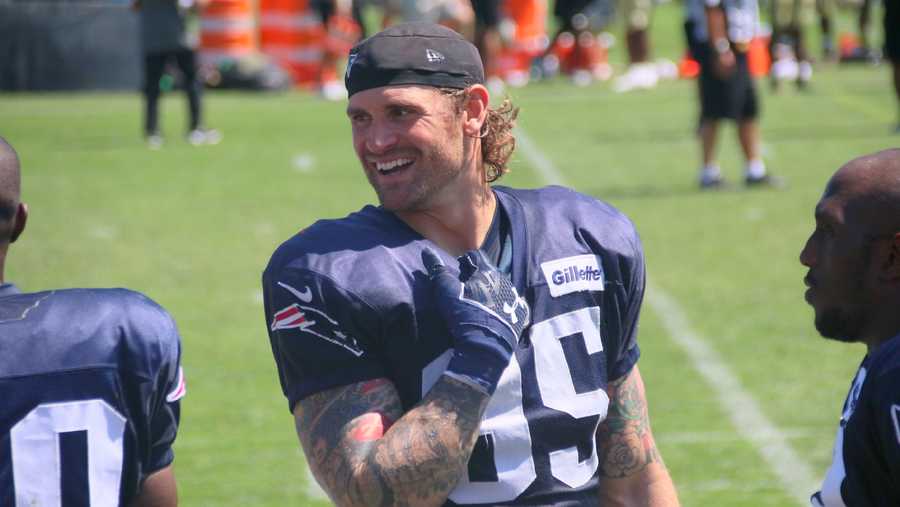 New Patriots defensive end Chris Long smiles on the sidelines.