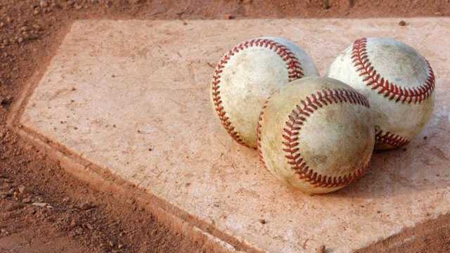 Baseballs on a dusty home plate.