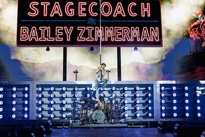 Indio, CA - April 24, 2026: Bailey Zimmerman swings off the stage to kick of his performance on the Mane Stage during the Stagecoach Country Music Festival at Empire Polo Club, in Indio, CA on April 24, 2026. (Allen J. Schaben / Los Angeles Times via Getty Images)