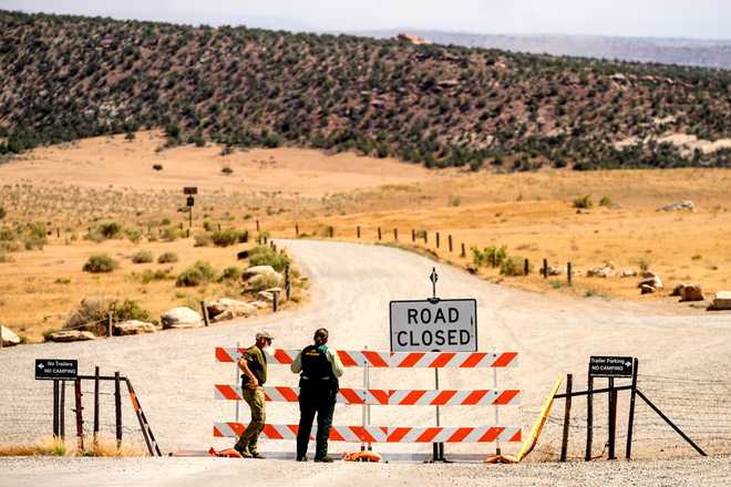 Law enforcement officers staff a roadblock as the Snyder Fire burns near Mack, Colo., on Sunday, June 28, 2026.