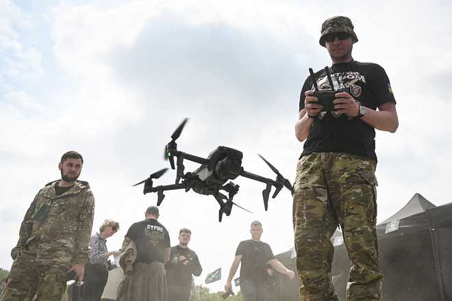 A Ukrainian serviceman pilots a drone during the "Wild Drones" racing competition  designed to simulate battlefield conditions  in Truskavets, Lviv region, on May 20, 2026, amid Russia's invasion of Ukraine. (Photo by YURIY DYACHYSHYN / AFP via Getty Images)