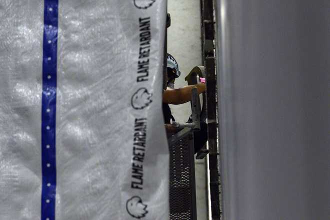 A worker removes a letter from President Donald Trump&amp;#39;s name from the wall of the John F. Kennedy Center for the Performing Arts in Washington, Saturday, June 13, 2026. (AP Photo/Cliff Owen)