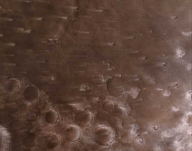 Dusty wind streaks extend about 30 miles (50 kilometers) across the Martian craters.